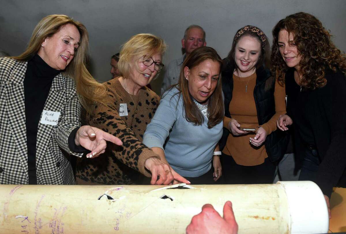 From left, Alice Pulliam, Nancy Pompa, Alice Berry, Crista Whiteman and Patti Hawley look over inscriptions on a time capsule unearthed at the Kids Kreations playground at Monroe Town Hall on March 29, 2022.