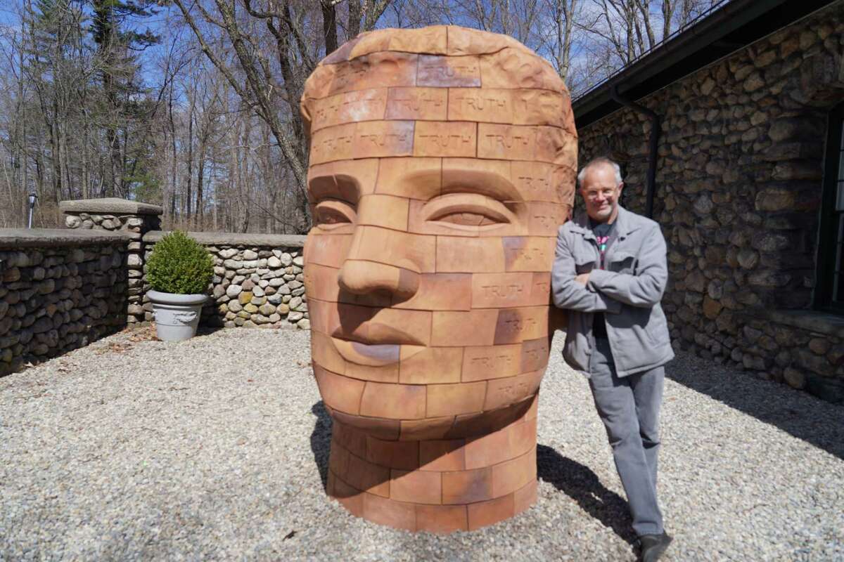 The 300-brick sculpture Brickhead - Truth has arrived early for the New Canaan Land Trust Sculpture Trail and stands outside the Carriage Barn in Waveny Park in New Canaan. Artist James Tyler leaned against his work on March 29, 2022.