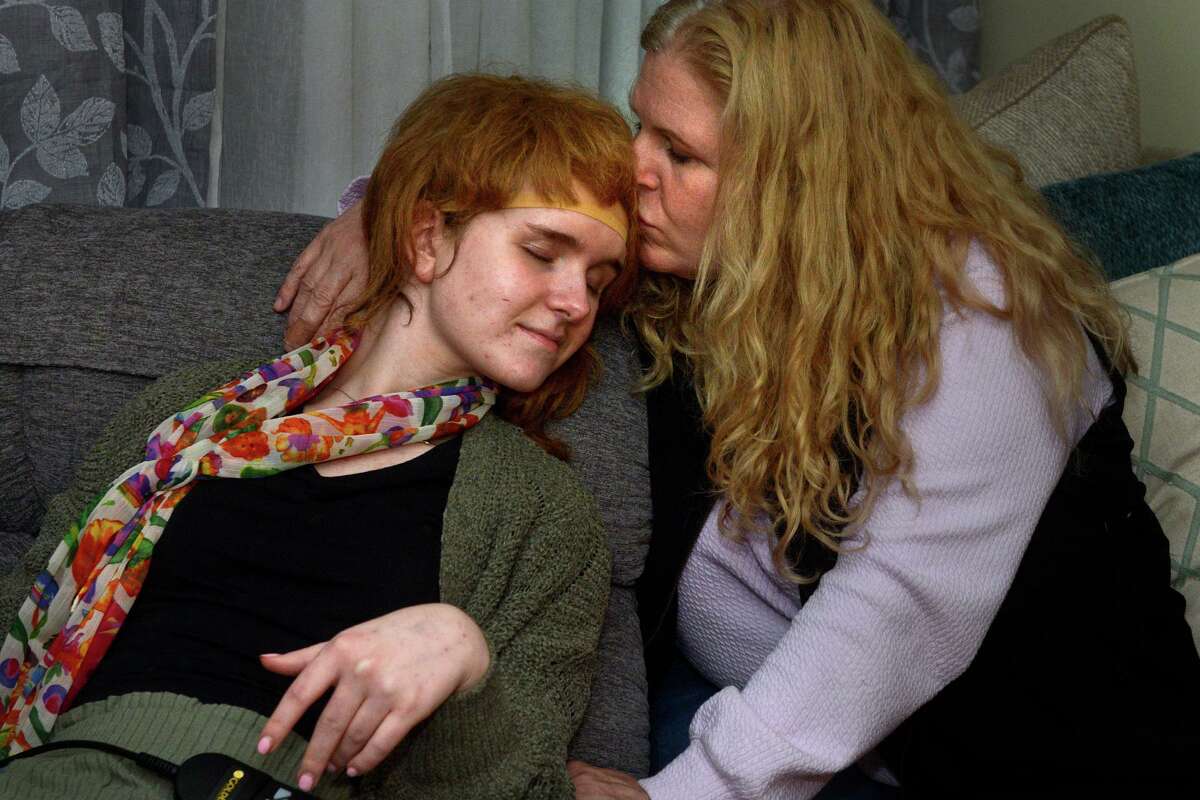Eva Houlihan gets a kiss from her mother, Elizabeth Gower, on Eva’s first night back home in Woodbury, Conn. Oct. 5, 2021. Eva has been in the hospital recovering from a car accident in Southbury last April that left her boyfriend dead.