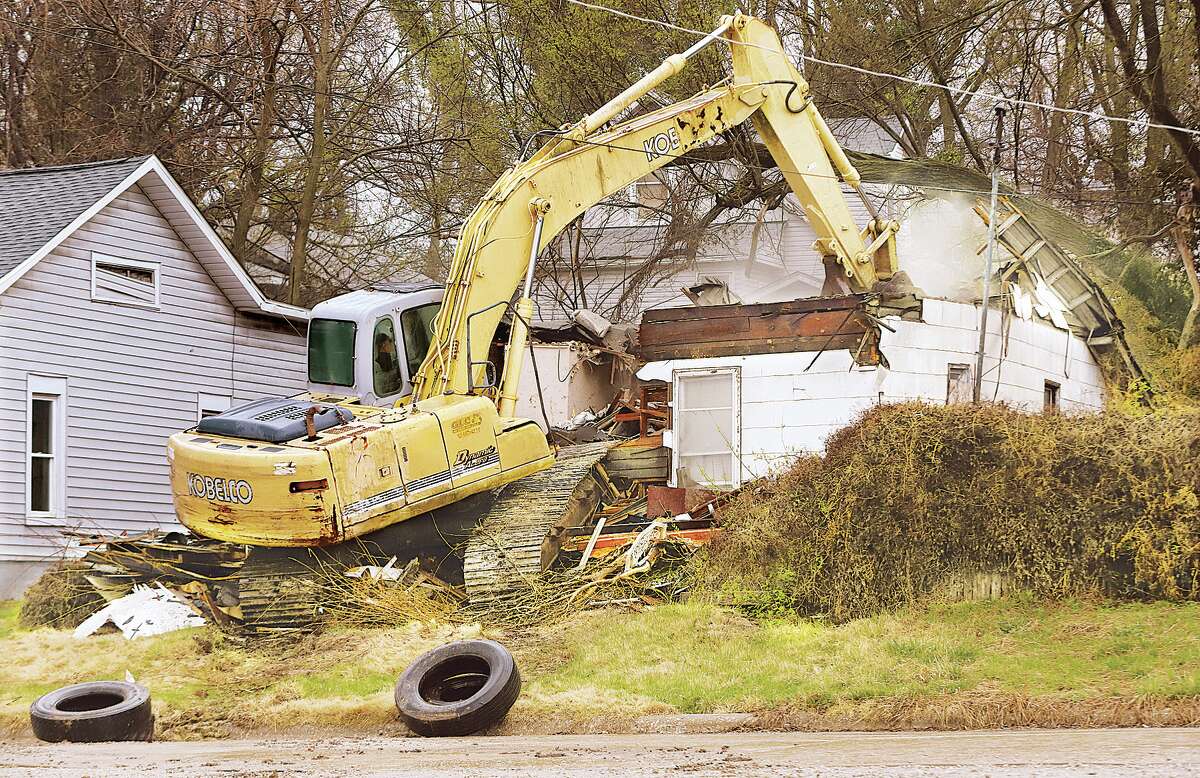 John Badman|The Telegraph The driver of a trackhoe made himself at home Wednesday as he drove into a house in the 1600 block of Walker Street in Alton. The house was being razed. Many houses are on the city's demolition list with condemned structures being demolished on a regular basis.