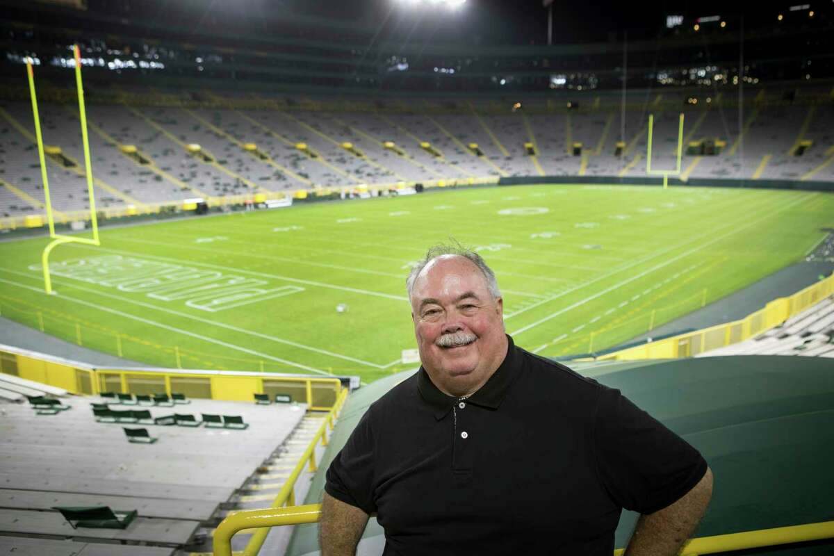 Houston Chronicle sports writer John McClain poses for a photo in an empty Lambeau Field after an NFL pre-season football game between the Houston Texans and the Green Bay Packers Saturday, Aug. 14, 2021, in Green Bay, Wis.