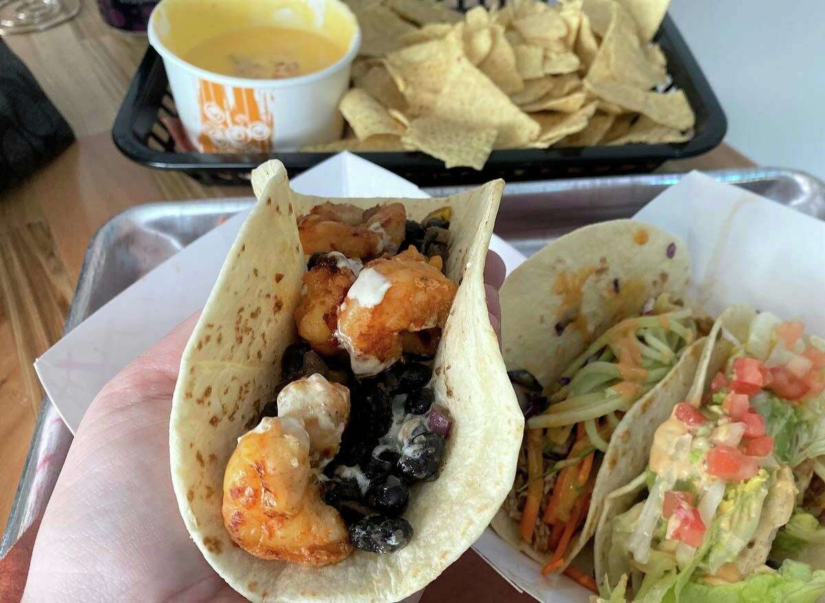 A spicy adobo-marinated shrimp taco with black beans, corn and crema verde; a Newport chicken taco with guacamole, bacon and chipotle mayo; and a Thai chicken taco with red curry peanut sauce.