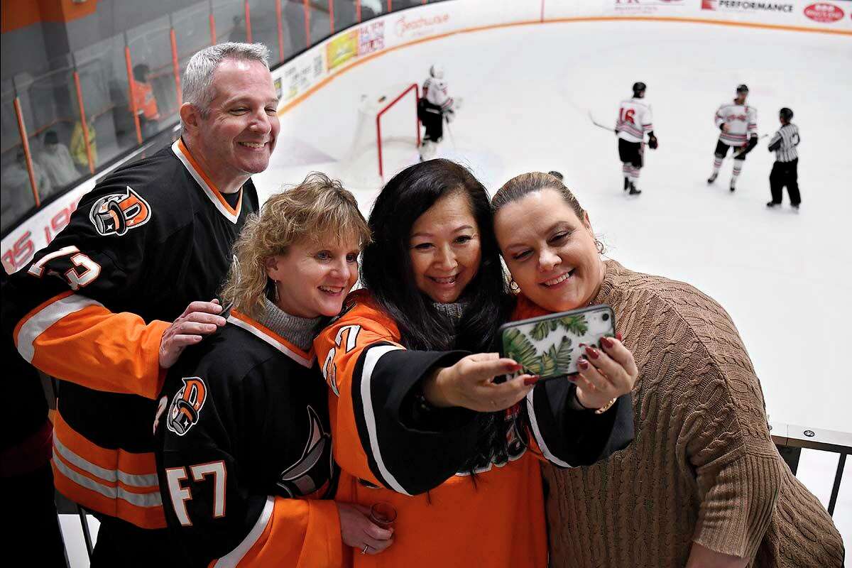 From the left fans Ron Rogell, Lisa Stalker, Lisa Anderson, and Alex Szajkowska take a selfie together during a game between the Danbury Hat Tricks and the Carolina Thunderbirds, Friday, Jan. 28, 2022, at Danbury Ice Arena in Danbury, Conn. Anderson's son is player Cory Anderson.