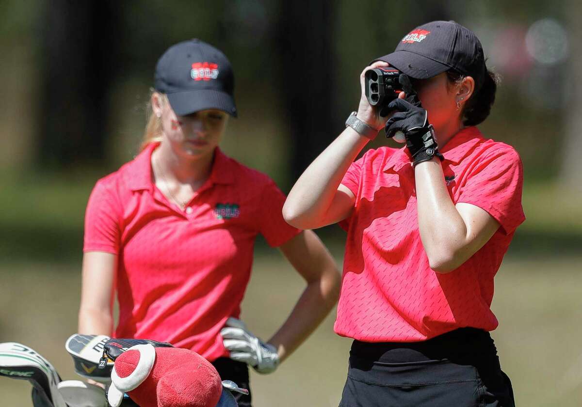 Blythe Bowman of The Woodlands checks the distance to the 5th green during the District 13-6A golf championships, Wednesday, March 30, 2022, in Magnolia.