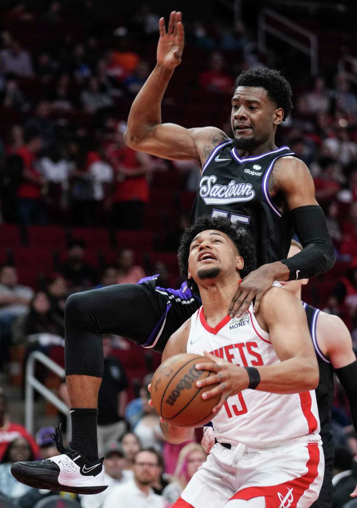 Houston Rockets guard Daishen Nix (15) looks to take a shot with Sacramento Kings guard Josh Jackson (55) hanging on his shoulder during the first half of an NBA basketball game Wednesday, March 30, 2022, in Houston.
