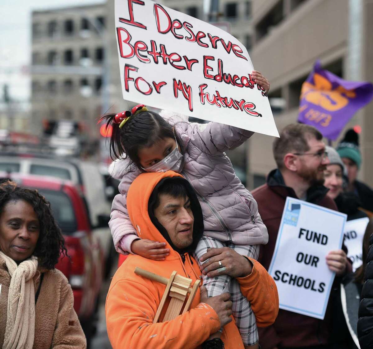 Walter Bueno of New Haven holds his daughter, Brianna, 5, during a protest calling for more funding for education in front of Board of Education offices before a march to City Hall in New Haven on March 30, 2022.