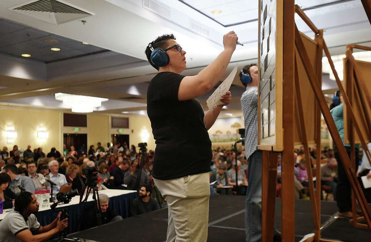 Claire Rimkos, of South Grafton, MA, fills in the the C division championship playoff puzzle on stage in front of a packed house at the 42nd Annual American Crossword Puzzle Tournament at the Stamford Marriott in Stamford, Conn. on Sunday, March 24, 2019.