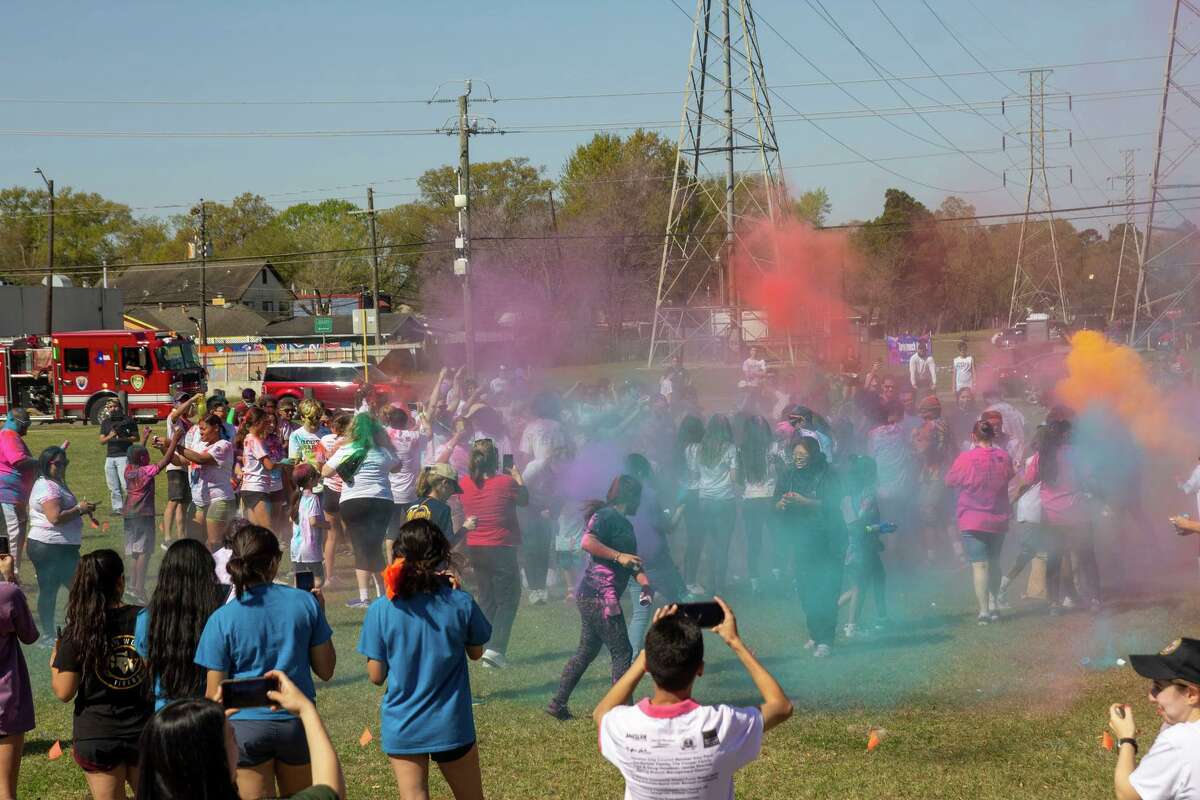 Participants in Community Project Prom’s Color Run fundraiser for Northbrook and Spring Woods High School proms engage in colored powder throws by Northbrook High School on Saturday, March 26.
