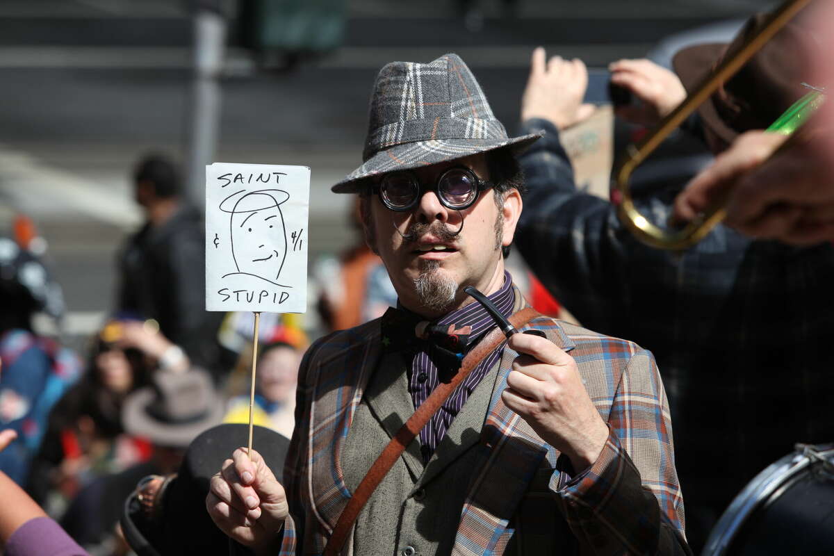 Professor Violet from San Francisco holds his sign during the 35th annual Saint Stupid's Day Parade in front of 100 California St. in San Francisco on Monday, April 1, 2013.