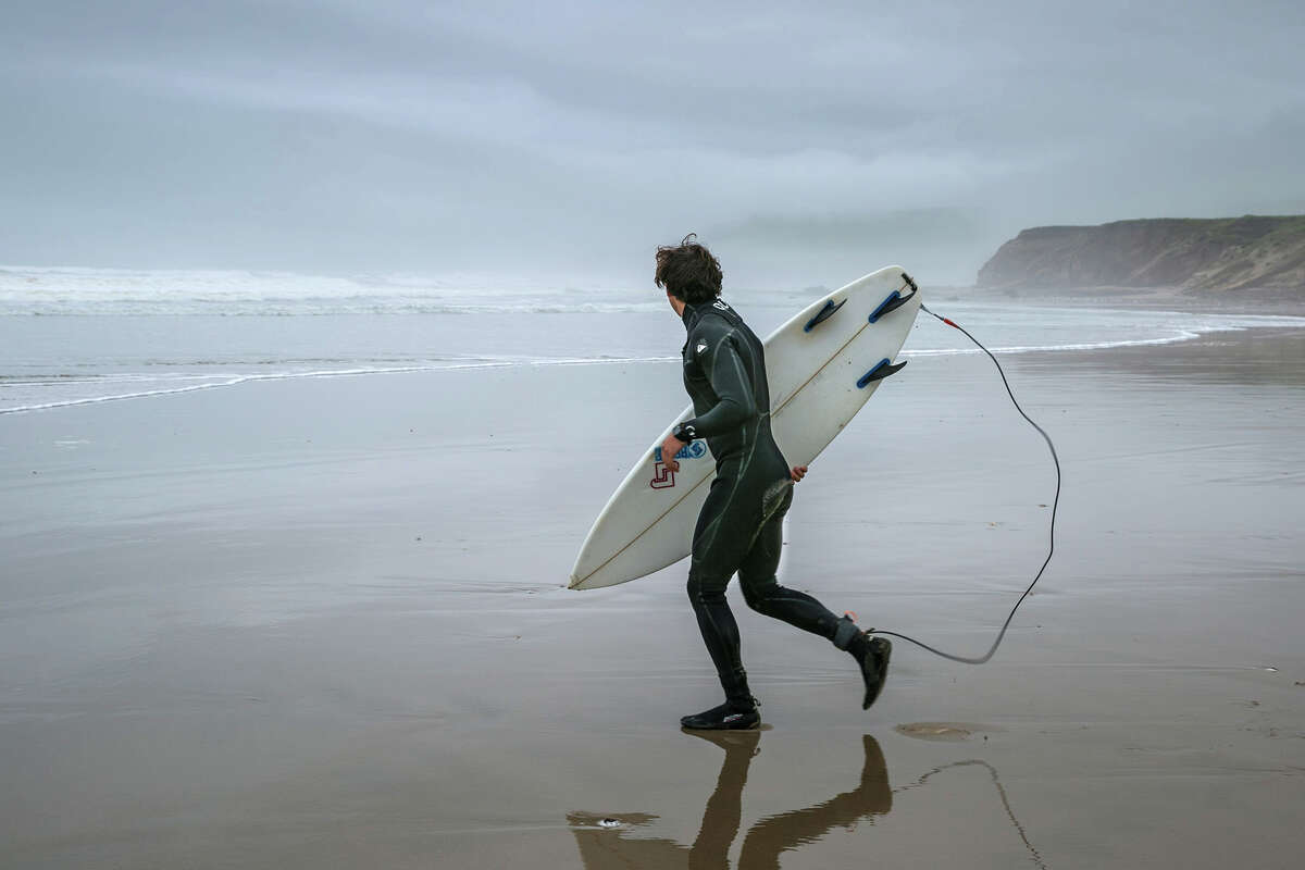 A surfer heads into the cold water at Jalama Beach, Calif. The beach is home to the closest break to nearby Hollister Ranch, which, starting April 1, 2022, is supposed to be open for easier public access. 