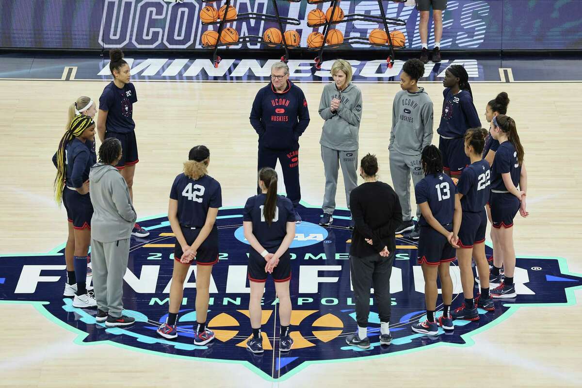 MINNEAPOLIS, MINNESOTA - MARCH 31: UConn Huskies players and coaches stand on the logo for the Women's Final Four tournament during a practice session at Target Center on March 31, 2022 in Minneapolis, Minnesota. The UConn Huskies will play the Stanford Cardinal on April 1, 2022. (Photo by Andy Lyons/Getty Images)