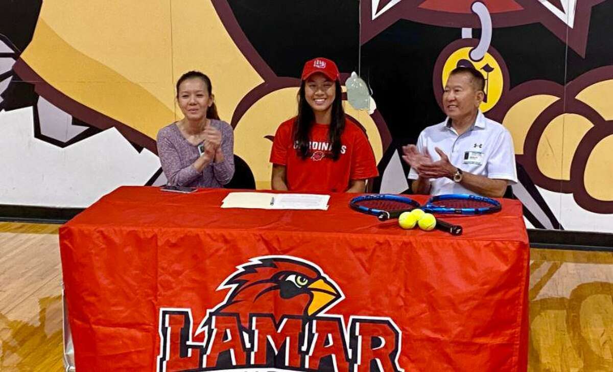 Megan Do sits next to her parents as she signs with Lamar University tennis during a ceremony at Nederland High School on Thursday.