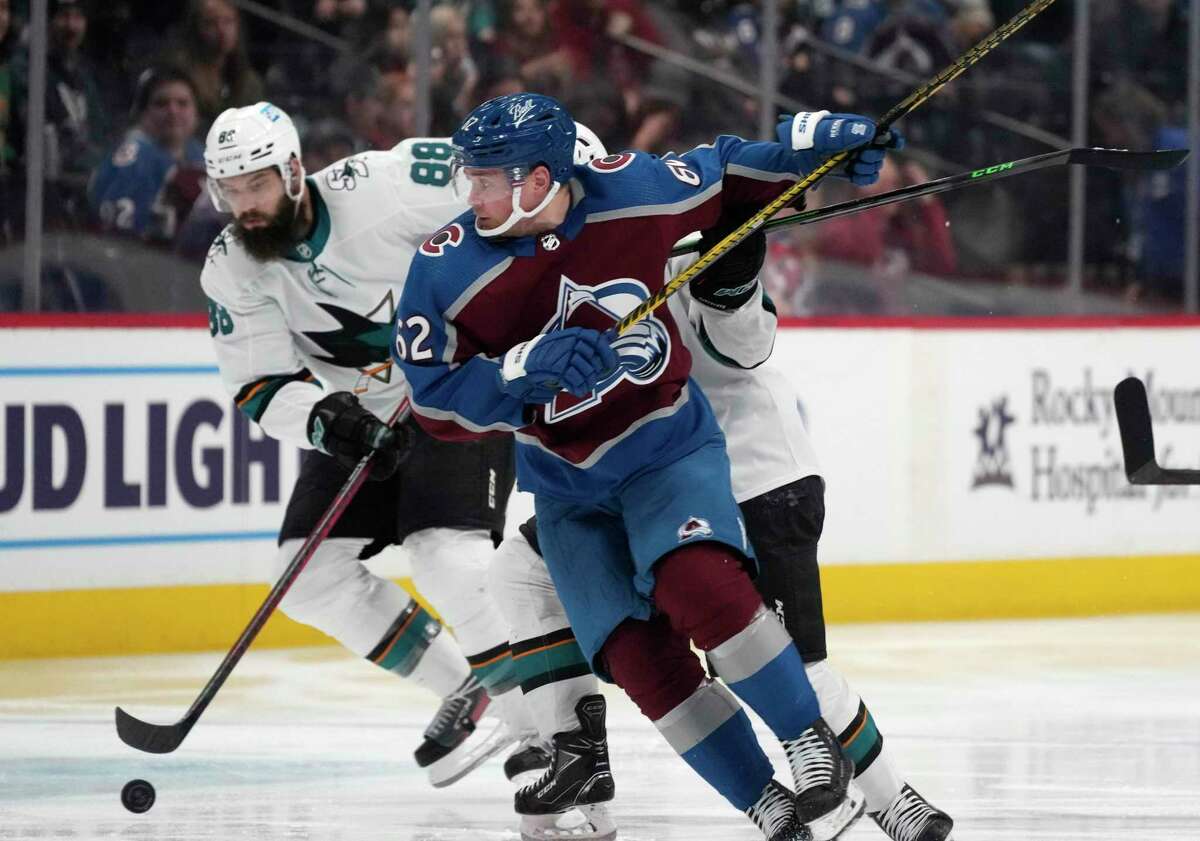 Colorado Avalanche left wing Artturi Lehkonen, front right, tries to block a pass off the stick of San Jose Sharks defenseman Brent Burns, left, in the second period of an NHL hockey game Thursday, March 31, 2022, in Denver. (AP Photo/David Zalubowski)