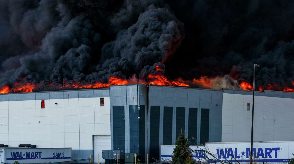 A massive fire burns inside a Walmart distribution center in Plainfield, Ind., near Indianapolis International Airport, Wednesday, March 16, 2022.