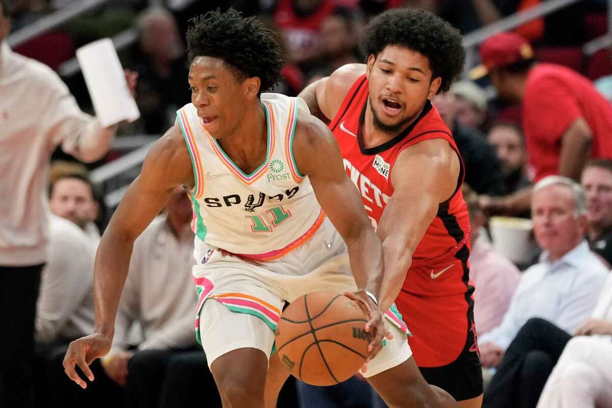 San Antonio Spurs guard Joshua Primo, left, dribbles as Houston Rockets guard Daishen Nix defends during the second half of an NBA basketball game, Monday, March 28, 2022, in Houston. (AP Photo/Eric Christian Smith)