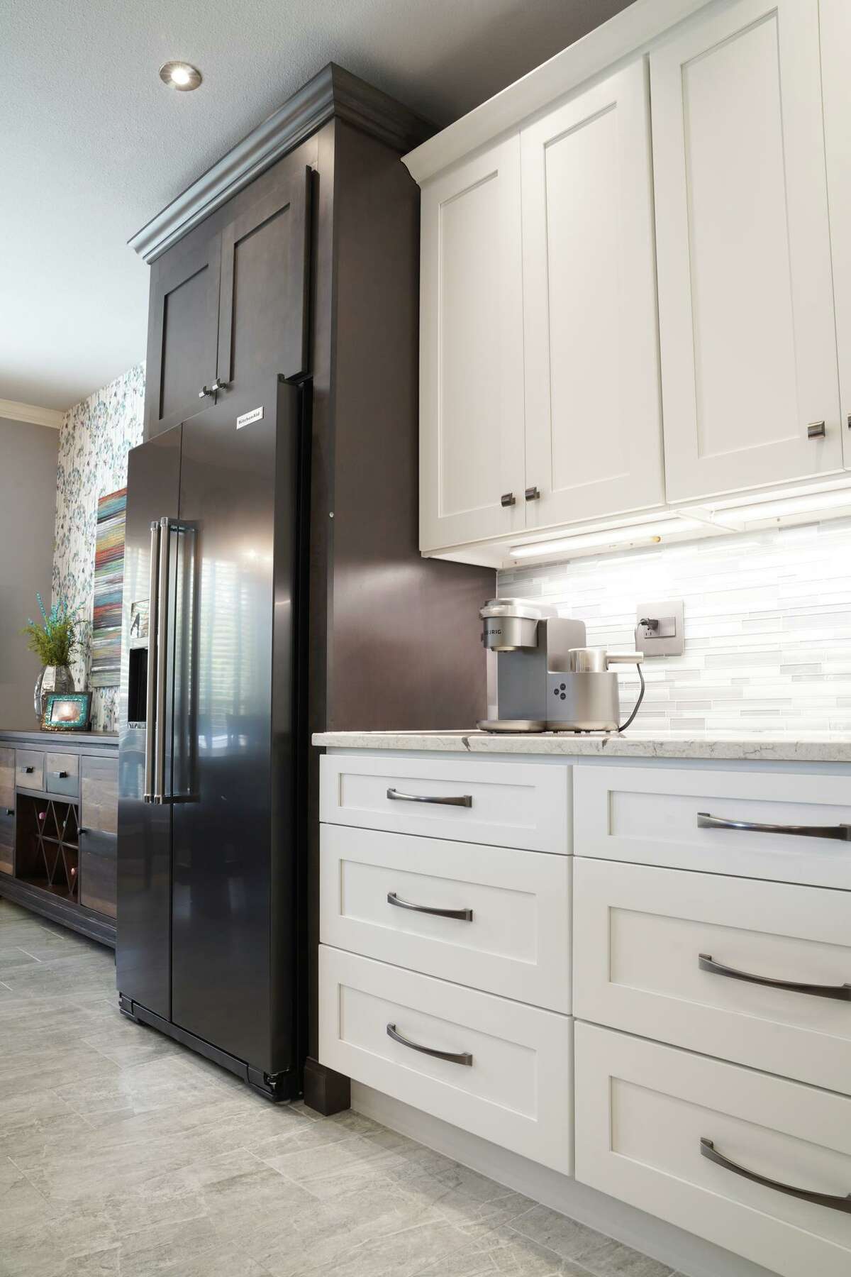 Penny and Don Wuebben decided on a two-color cabinet scheme, opting for a slate stain on the cabinets at either end of the L-shaped counter area and white for the rest.