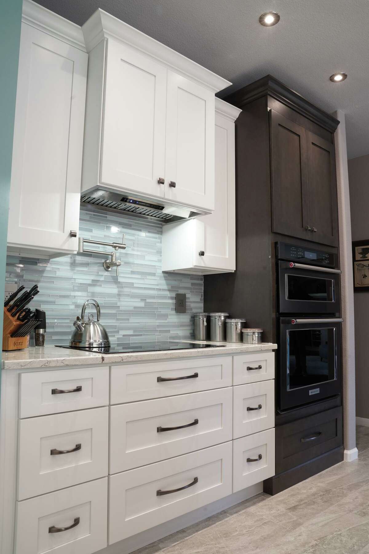 The kitchen has a silver-and-blue glass tile backsplash and a pot-filler above the stove.