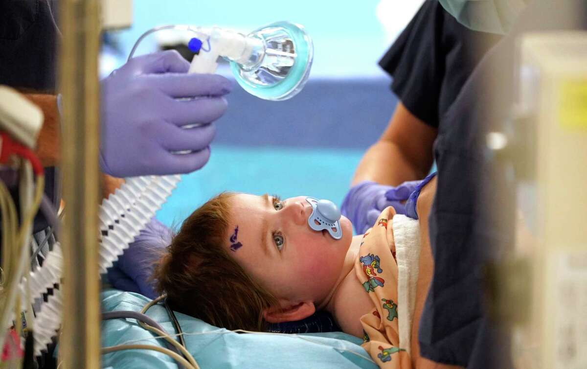 Walker Hicks 9-month-old lays on an operating table as he prepared for surgery at Children’s Memorial Hermann Hospital Friday, March 25, 2022, in Houston. The operation replaced a piece of his skull that was removed to alleviate the swelling in his brain during an emergency surgery in October 2021.