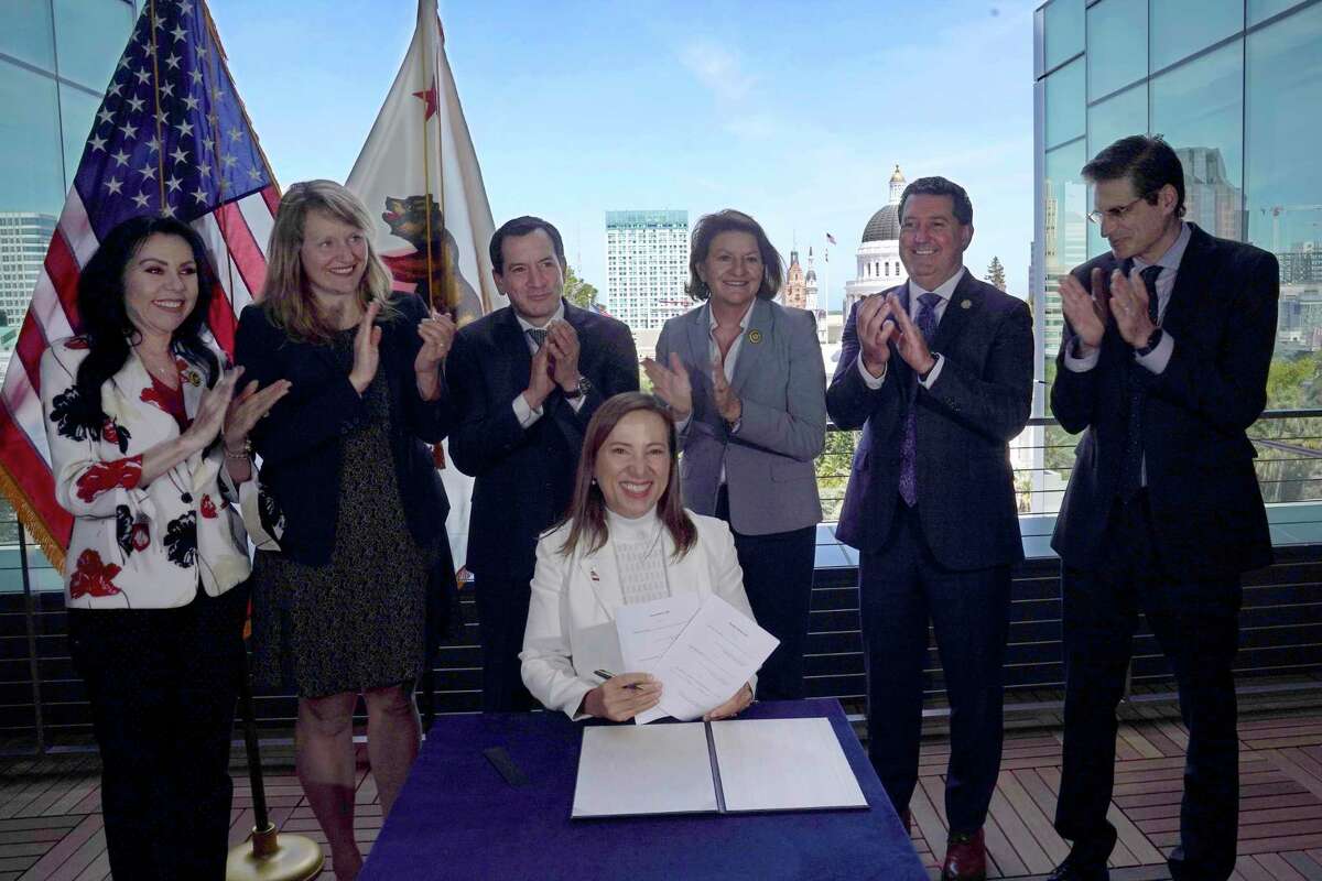 California Lt. Gov. Eleni Kounalakis displays a pair of bills she signed into law in Sacramento on March 31.
