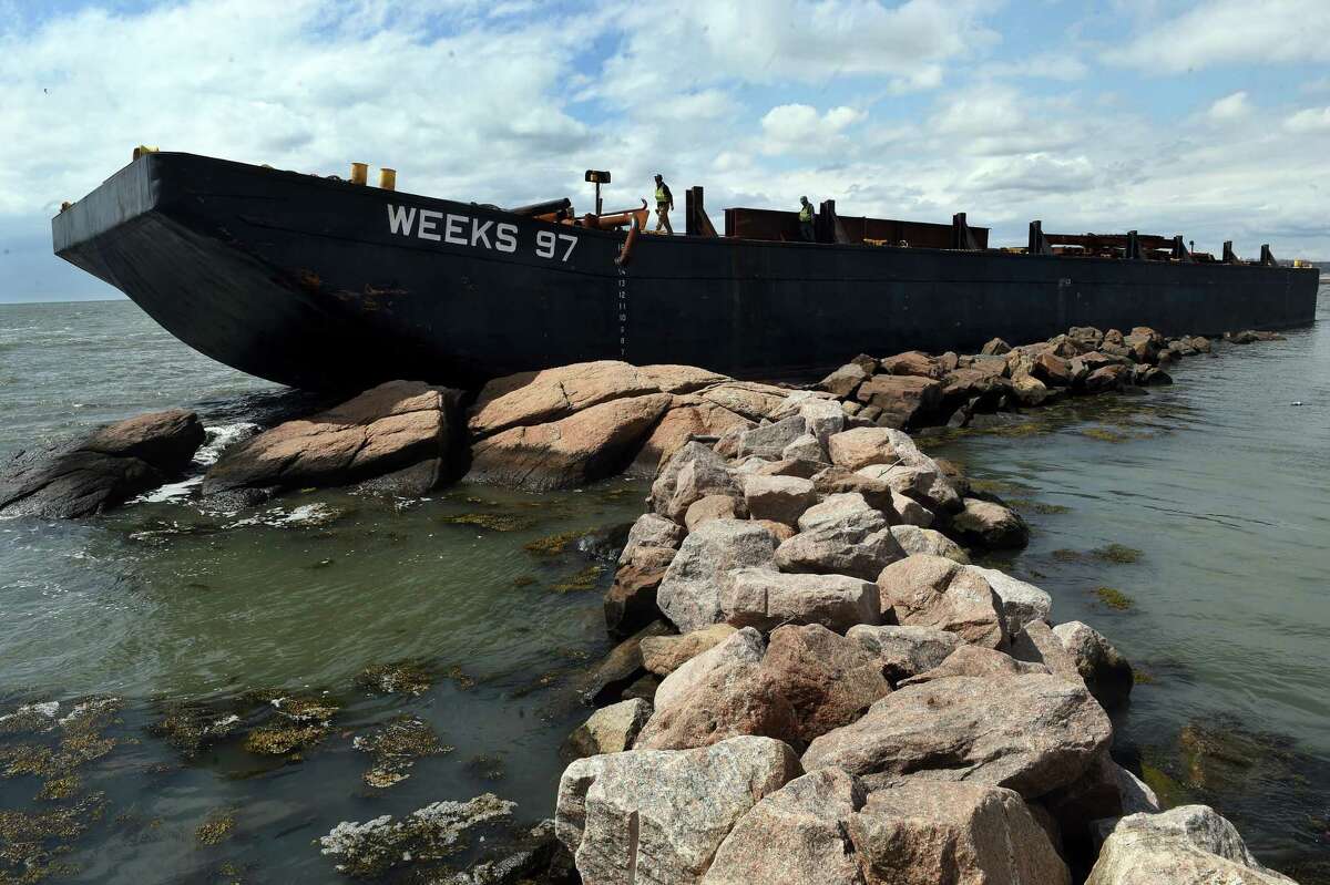 A construction barge is grounded on rocks next to the Sachems Head Yacht Club in Guilford on April 1, 2022.