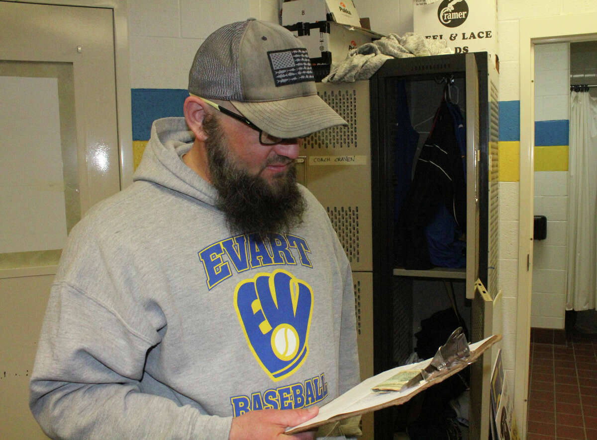 Evart baseball coach Josh Johnson reviews his notes after a Thursday practice.