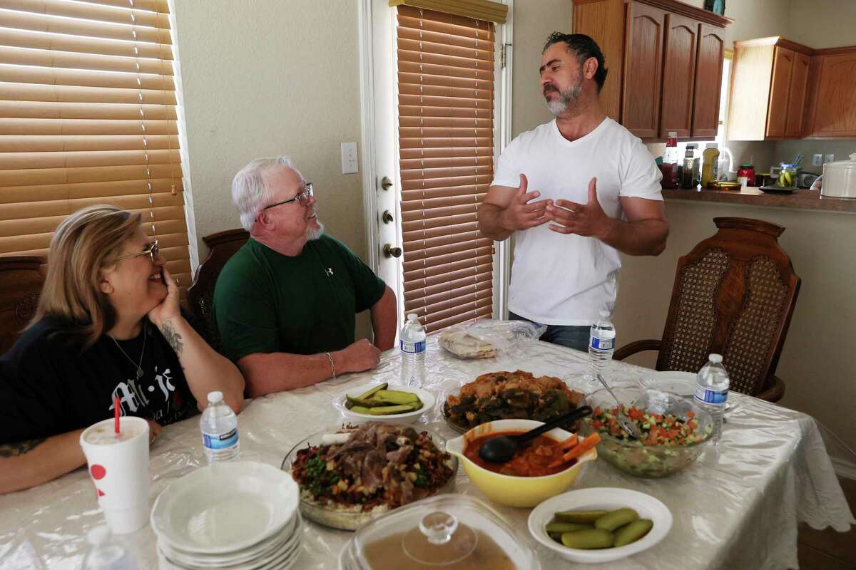 Iraqi immigrant Abdul Abdallah, 45, right, and his family entertain long-time friend, Pam Allen, left, and her husband, Tim, for lunch at their home Friday, March 18. Abdallah served as an interpreter for the US Army for five years. He and his family immigrated to the US in 2010. Since then, he's acted as a calming force in the North Side refugee community, helping resettlement caseworkers tend to the needs of immigrants from around the world.