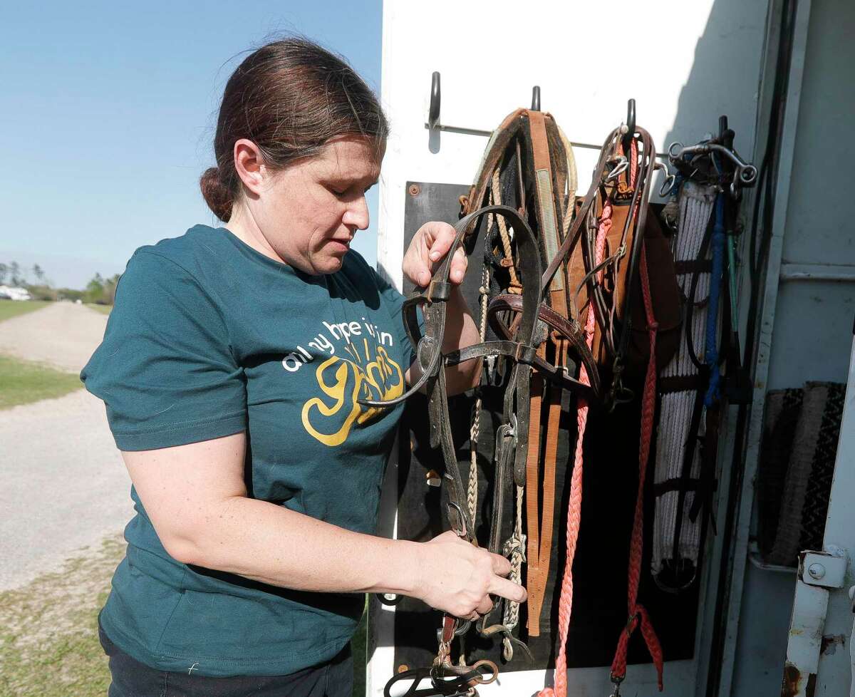 Kimberly Conner with the Montgomery County Precinct 2 Constable’s Mounted Posse prepare her gear for another evening at the Montgomery County Fair and Rodeo, Friday, April 1, 2022, in Conroe. The 15-member volunteer group adds to law enforcement surveillance efforts at the fairgrounds during some of the rodeo and fair’s busiest days.
