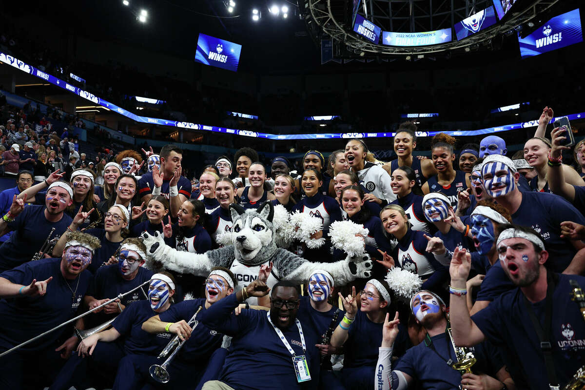 MINNEAPOLIS, MINNESOTA - APRIL 01: The UConn Huskies pose with the mascot, cheerleaders, and members of the band after defeating the Stanford Cardinal 63-58 in the second half during the 2022 NCAA Women's Final Four semifinal game 2 at Target Center on April 01, 2022 in Minneapolis, Minnesota. (Photo by Elsa/Getty Images)