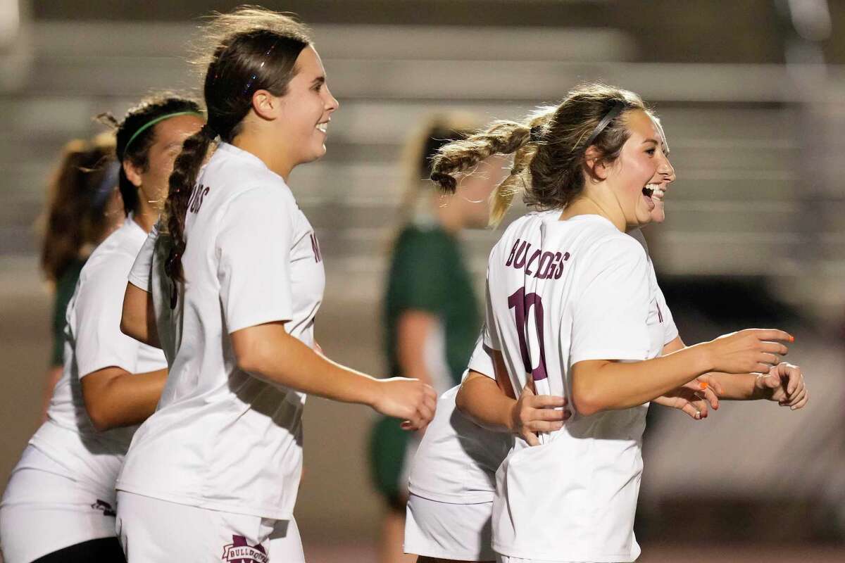 Magnolia’s Laney Gonzales, right, celebrates her goal during the second half of a Region III-5A quarterfinal high school soccer playoff game against Kingwood Park, Friday, April 1, 2022, in Humble.