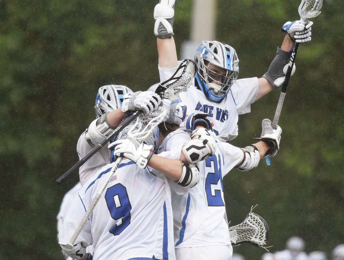 Darien players celebrate after a goal against Staples in the FCIAC boys lacrosse final at Dunning Field in New Canaan in 2021.