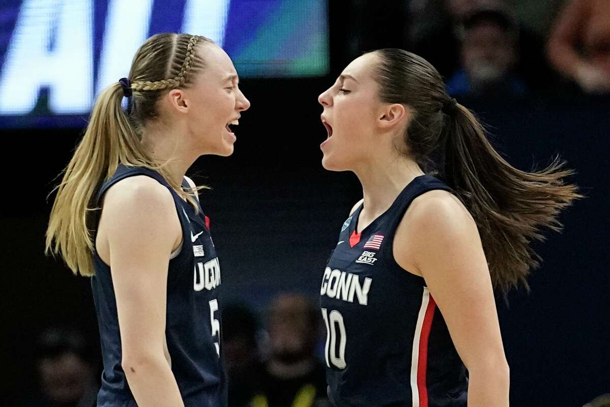 UConn's Nika Muhl is congratulated by Paige Bueckers after a score during the first half of a college basketball game in the semifinal round of the Women's Final Four NCAA tournament Friday, April 1, 2022, in Minneapolis. (AP Photo/Eric Gay)
