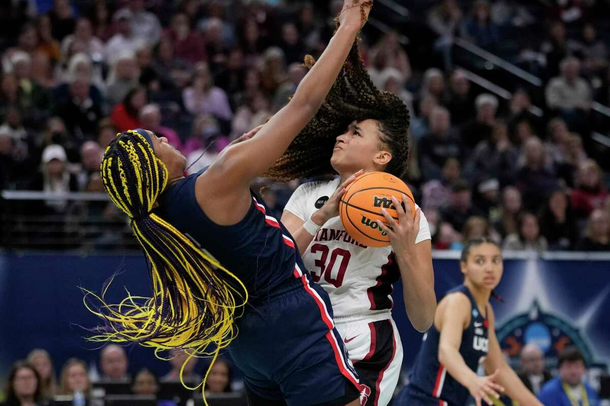 Stanford's Haley Jones is called for a charge into UConn's Aaliyah Edwards during the second half of a college basketball game in the semifinal round of the Women's Final Four NCAA tournament Friday, April 1, 2022, in Minneapolis. (AP Photo/Charlie Neibergall)