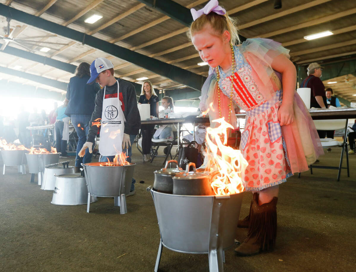 Saige McKinley cooks on charcoal as 50 kids took part in the inaugural KidzQ barbecue cook off during the Montgomery County Fair and Rodeo, Saturday, April 2, 2022, in Conroe.