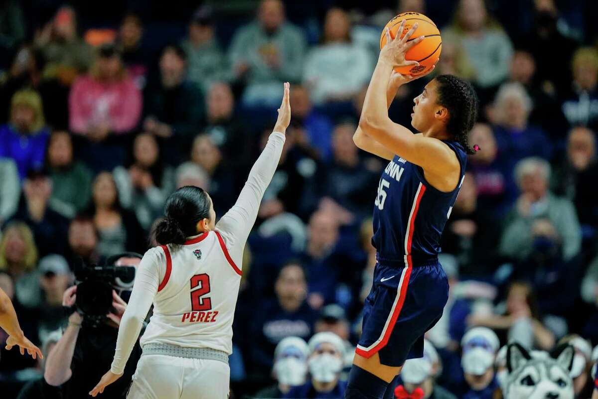 UConn’s Azzi Fudd, right, puts up a shot against NC State’s Raina Perez during their East Regional final game March 28. Fudd’s parents helped her navigate her freshman season, which included injuries, adversity and a Final Four appearance.