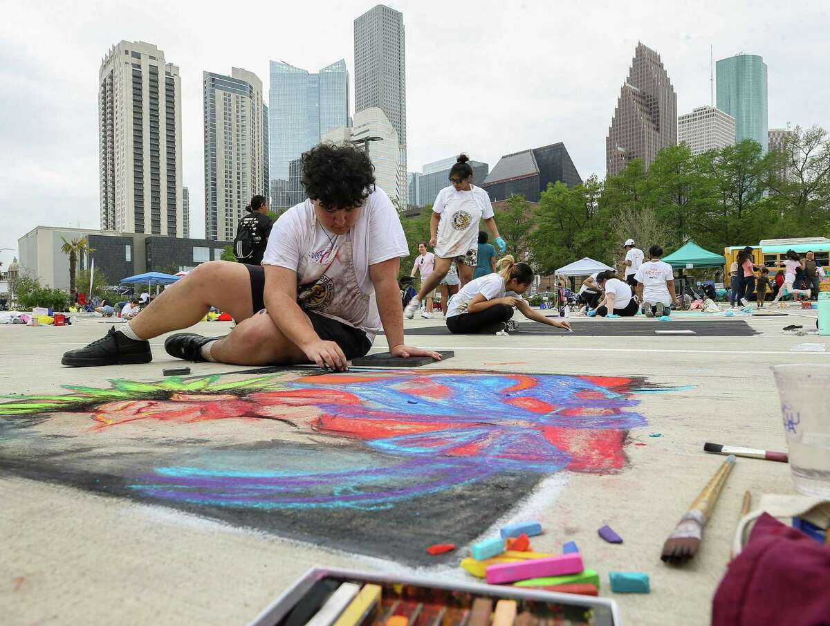 Ivan Granados, 16, works on his chalk art piece during the Via Colori Houston festival at the Post HTX building on Saturday, April 2, 2022, in Houston. The mixed-use adaptive reuse building opened near the Theater District in downtown Houston in late 2021.
