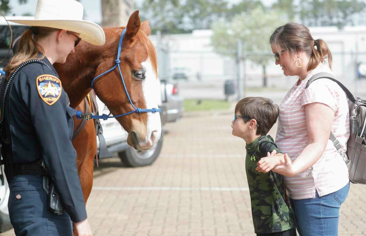 Rixon Cota kisses a horse with the The Montgomery County Sheriff's Office’s goodbye during an event, Saturday, April 2, 2022, in Conroe. The law enforcement agency partnered with Thrive Autism Foundation, a nonprofit formed to help children with autism gain access to individualized high-quality education, therapies, and other services.