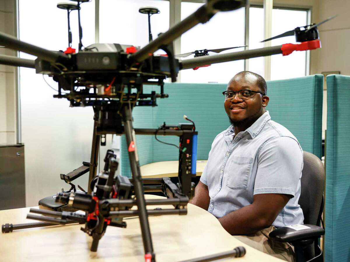 Graduate student Iyare Oseghae, a San Antonio native, sits beside a drone he and other students use to collect hyperspectral imaging data at the University of Texas at San Antonio.