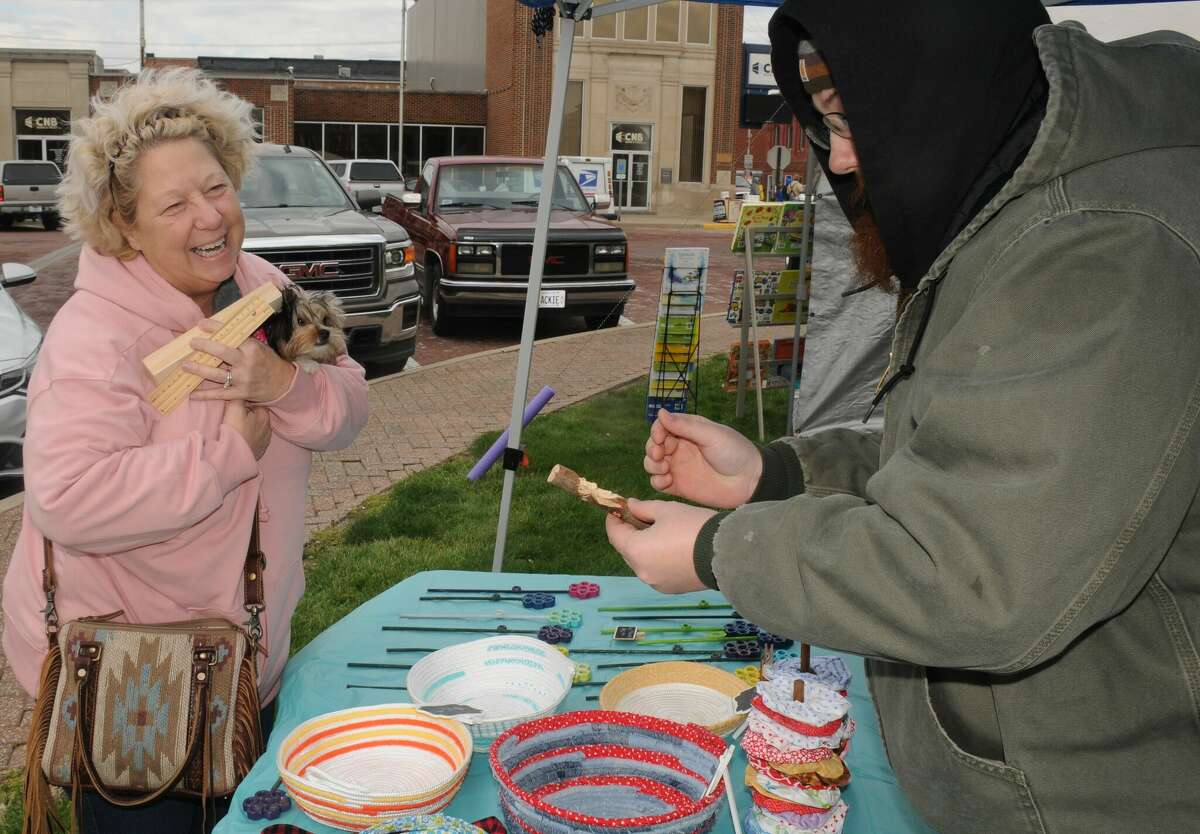 Ginger Sperry and her dog, Claire, compare hand-made crafts with a Carlinville Market Days vendor. The monthly events kicked off the 2022 season this weekend.