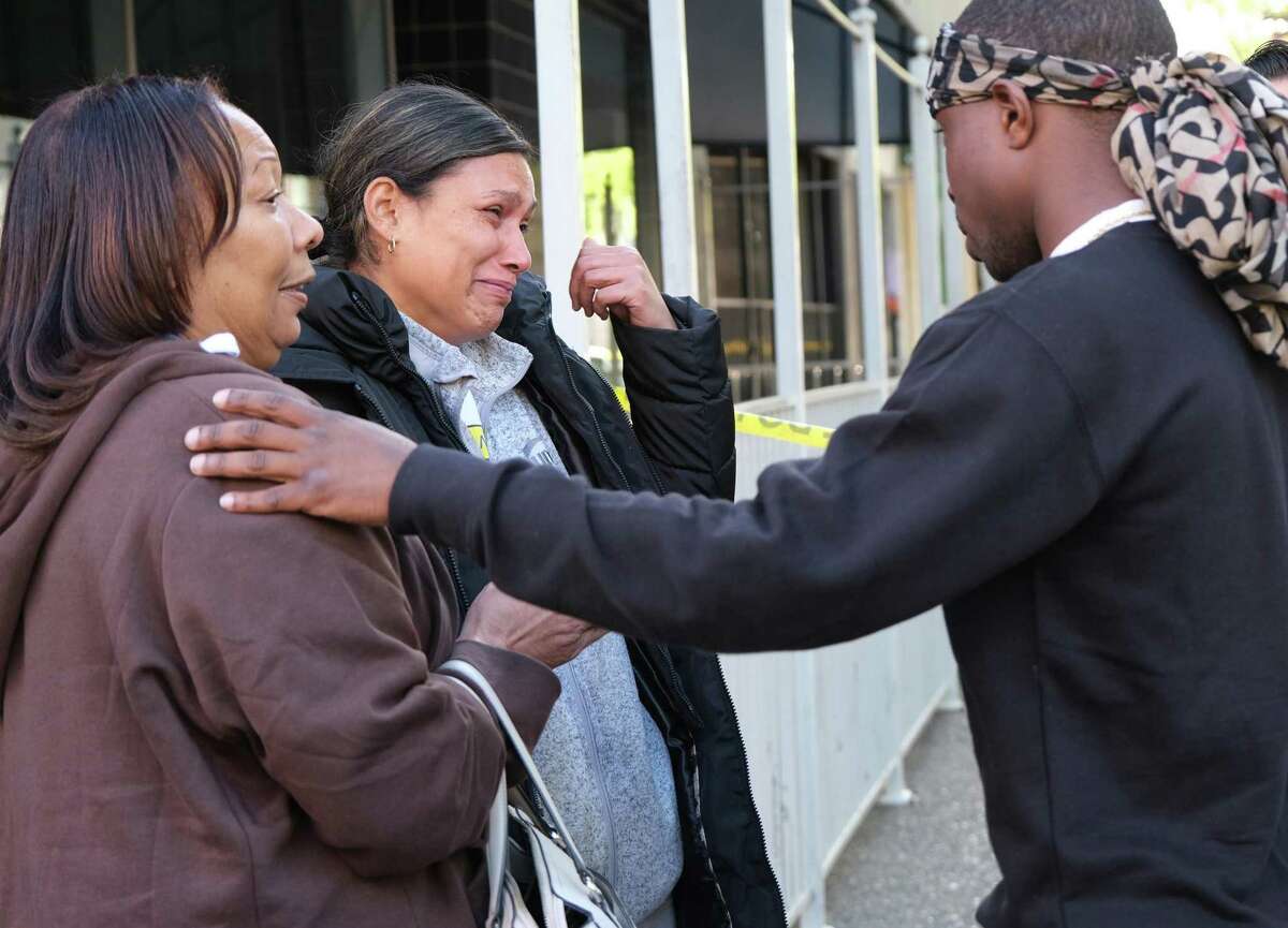 Leticia Fields (center) is consoled by mother-in-law Pamela Harris and activist Stevante Clark as she waits for word about her husband after a mass shooting in downtown Sacramento.
