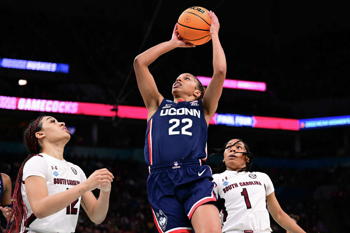 Evina Westbrook of the Connecticut Huskies puts up a shot between Brea Beal and Zia Cooke of the South Carolina Gamecocks during the championship game of the NCAA Womens Basketball Tournament at Target Center on April 3, 2022 in Minneapolis, Minnesota.