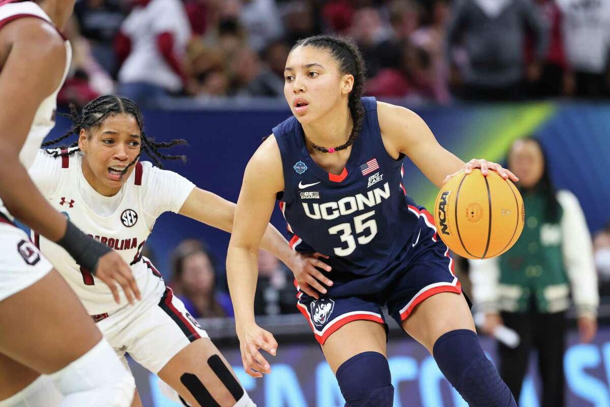 UConn’s Azzi Fudd of the Connecticut Huskies tries to dribble to the basket while defended by South Carolina’s Zia Cooke during Sunday’s national championship game. Fudd was limited to just 17 minutes becasuse of an illness.