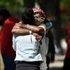 Two women hug each other at the scene of a mass shooting in Sacramento, Calif., on Sunday, April 3, 2022. (Jose Carlos Fajardo/Bay Area News Group via AP)