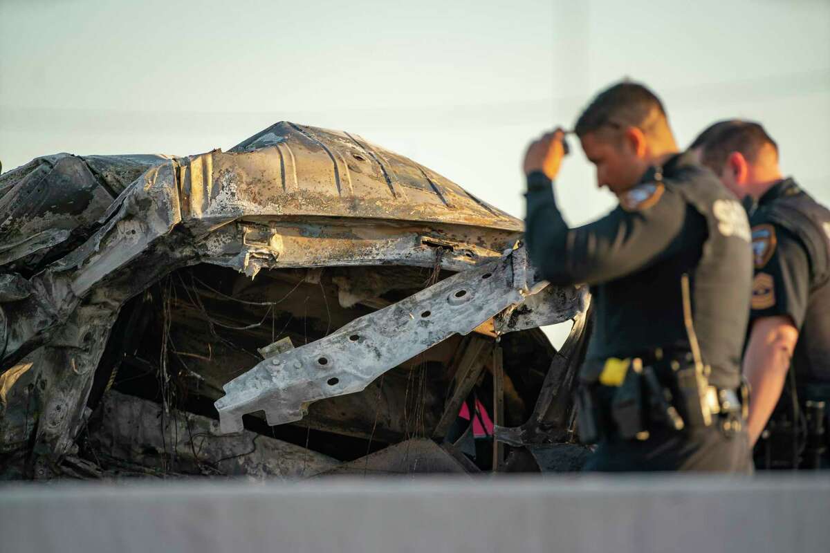 Harris County Sheriff’s Deputies walk past the wreckage of a vehicle involved in an accident on the South Sam Houston Tollway between Hillcroft and Fondren on Saturday, April 2, 2022, in Houston.