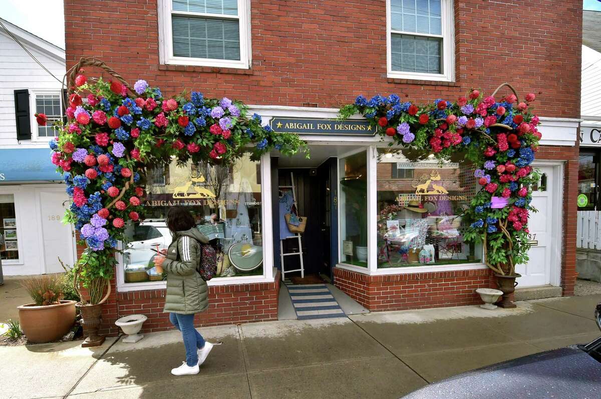 A pedestrian walks past Abigail Fox Designs in Old Greenwich, Conn., on Friday April 1, 2022. The gift shop has been given notice from the town to remove its flowery storefront design.