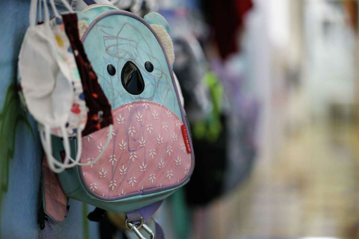 A child’s backpack hangs on a rack in the hallway Tuesday, Oct. 26, 2021, at Cradles 2 Crayons Early Learning Academy in Houston.