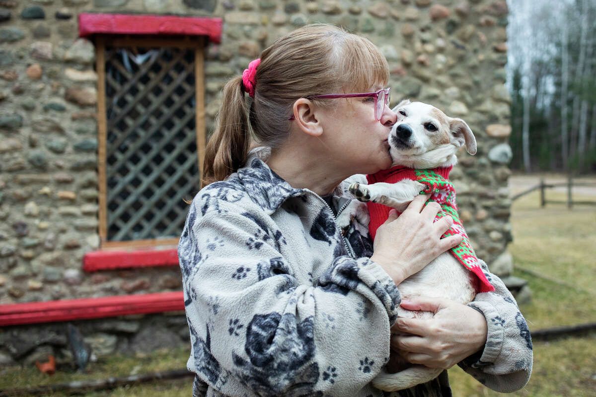 Joanne Sparkman gives a kiss to her fourteen-year-old Jack Russell Terrier, named Maya, Friday, April 1, 2022 at their home in Gladwin.