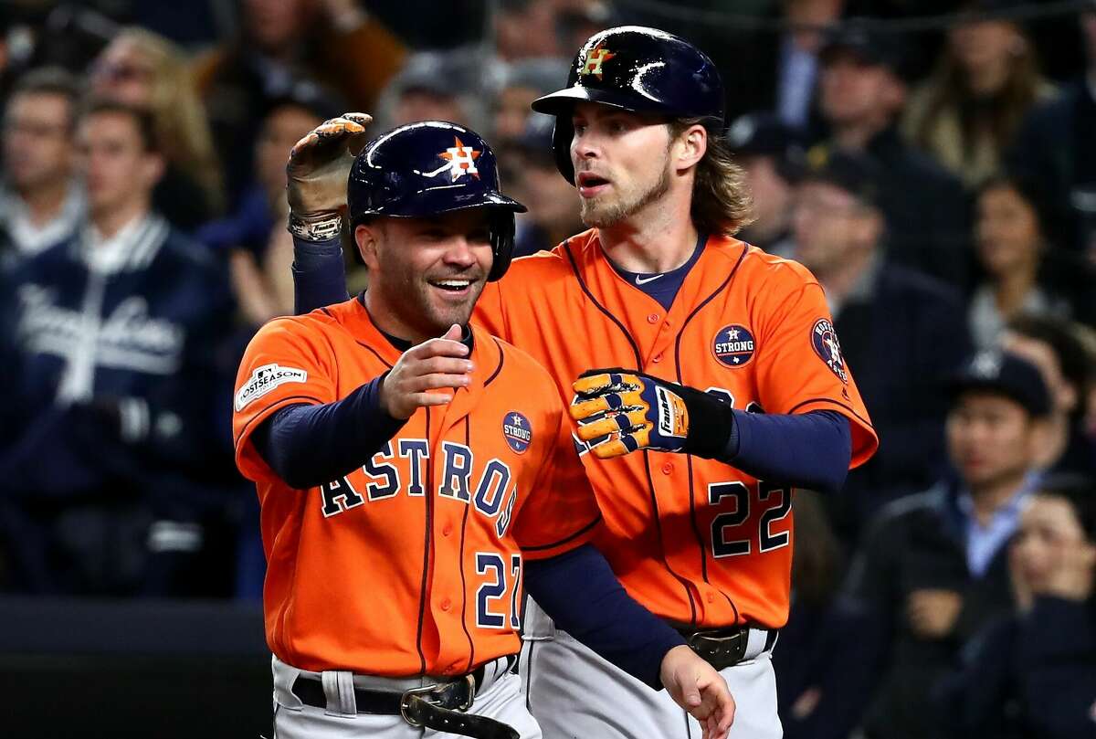 Jose Altuve and Josh Reddick of the Houston Astros celebrate after scoring on a Yuli Gurriel three-run double during the sixth inning against the New York Yankees in Game Four of the American League Championship Series at Yankee Stadium on October 17, 2017 in the Bronx borough of New York City.