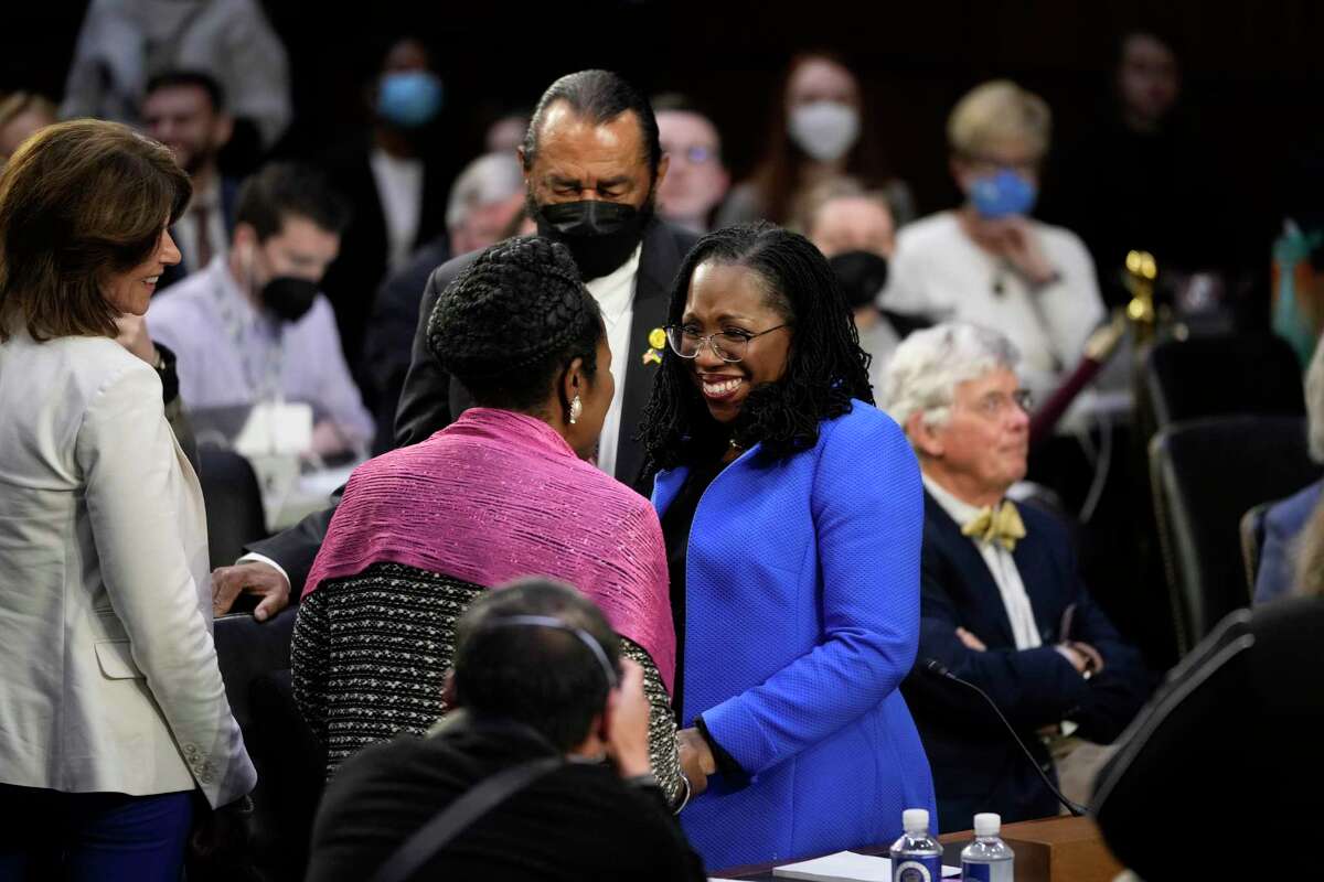 U.S. Supreme Court nominee Judge Ketanji Brown Jackson (R) talks to Rep. Sheila Jackson Lee (L) and Rep. Al Green after a break in her Senate Judiciary Committee confirmation hearing on March 23.