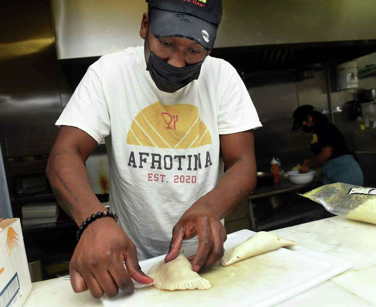 Chef Ohioma Odihirin, owner of the fusion catering company Afrotina, crimps the edges of a chicken empanada.