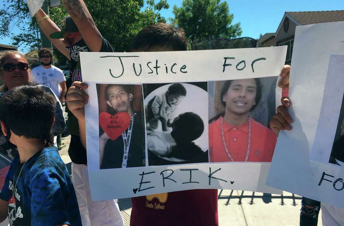 People at a vigil hold up a sign advocating justice two days after the fatal shooting of Erik Salgado, 23, who was killed by CHP officers June 6, 2020. The Alameda County D.A.’s Office said Monday that it will not file criminal charges against the officers.